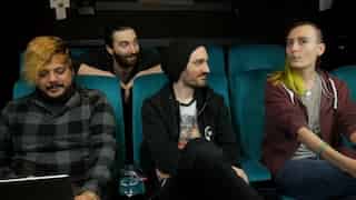 Screenshot of four Coffee Stainers sitting in the cinema seating of their old office. From left to right: Jace looking at a laptop, Birk in the rear row of seats looking at Hannah, Snutt looking at Hannah, and Hannah looking in the direction of (but not into) the camera.